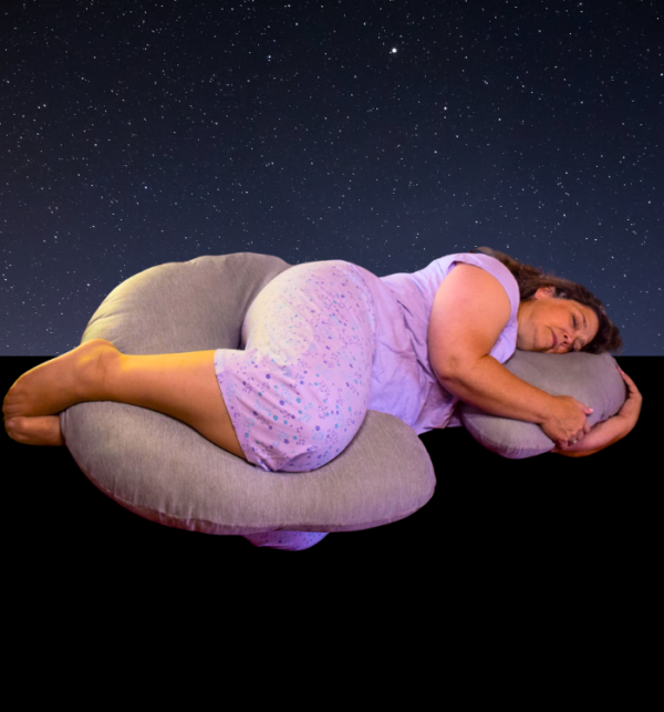 A woman peacefully sleeps on a pillow, with a serene starry sky illuminated behind her.