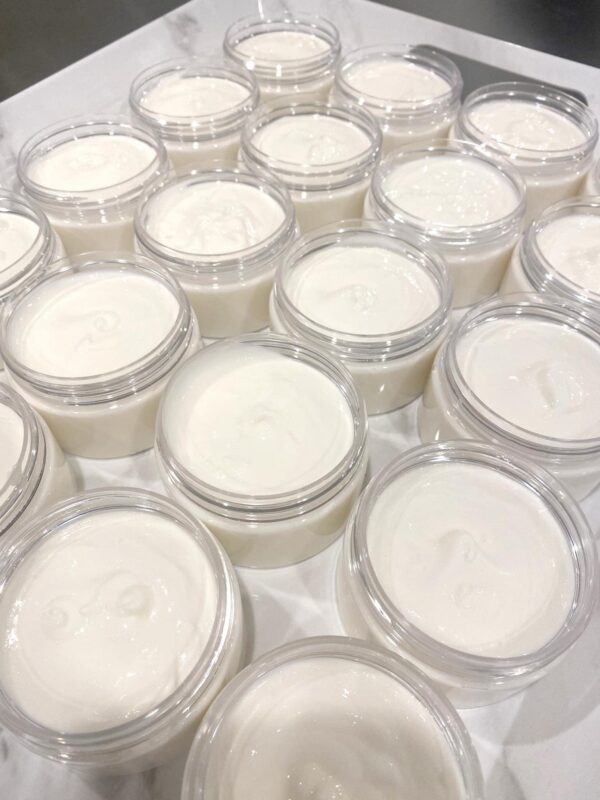 A tray displaying clear containers filled with cream, elegantly arranged on a table.